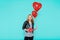 Beautiful young woman in leather jacket holding heart shaped balloons and wrapped birthday present. Valentine`s day concept.