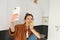 Beautiful young woman, lifestyle blogger records video of herself, takes selfie while biting an apple, sitting on