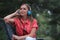 Beautiful young woman listening musing through headphones in park