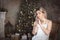 Beautiful young woman in the living room near the Christmas tree. Brooding or lonely, retro style