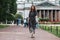 Beautiful young woman in a long dress walks along a path on the background of St. Isaac`s Cathedral in St. Petersburg