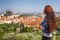 Beautiful young woman with long hair is looking on city panorama from observation desk. Prague. Czech Republic.