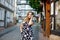 Beautiful young woman with long hairs in summer dress going for a walk in German city. Happy girl enjoying walking in