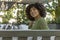 The beautiful young woman looks over her shoulder with a smile while sitting in the courtyard