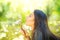 Beautiful young woman lying on green grass and blowing dandelions