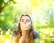 Beautiful young woman lying on green grass and blowing dandelions