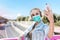 Beautiful young woman with medical face mask and earphones taking a selfie. Coronavirus covid concept. Coronavirus lifestyle