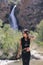 Beautiful young woman on the mountain and a waterfall