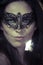 Beautiful young woman in mysterious black Venetian mask