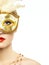 Beautiful young woman in mysterious golden Venetian mask