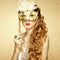 Beautiful young woman in mysterious golden Venetian mask