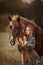 Beautiful young woman in national russian style with red draft horse