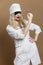 Beautiful young woman in nurse uniform with a syringe in her hand and a black eye patch. Sexy blonde with red lips. Compulsory