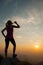 Beautiful young woman observing sunset with bottle of water