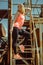 Beautiful young woman in an orange T-shirt is standing on rusty steps