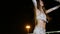 Beautiful young woman in oriental ethnic costume dances at night outdoor