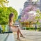 Beautiful young woman in Paris reading on the bench outdoors