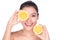 Beautiful young woman with perfect healthy skin and long brown hair day makeup bare shoulders holding orange lemon grapefrui