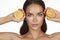 Beautiful young woman with perfect healthy skin and long brown hair day makeup bare shoulders holding orange lemon grapefruit