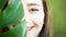 Beautiful young woman with perfect skin and natural make up. Teen model with green leaves. SPA, skincare and wellness. Close up,