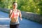 Beautiful young woman in pink top jogging in park