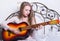 Beautiful young woman playing music on a bed with happiness and guitar