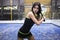Beautiful young woman playing paddle tennis indoor.