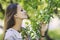 Beautiful young woman portrait next to a branch of a blossoming