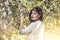 Beautiful young woman portrait next to a branch of a blossoming