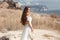 Beautiful young woman portrait in a white dress with woven handbag enjoying in the hay field. Natural beauty female. Romantic