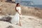 Beautiful young woman portrait in a white dress with woven handbag enjoying in the hay field. Natural beauty female. Romantic