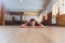 Beautiful young woman practices yoga asana Baddha Konasana - bound angle pose in the light yoga studio.