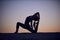 Beautiful young woman practices yoga asana King Pigeon pose rajakapotasana in the desert at night