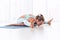 Beautiful young woman practices yoga asana Kurmasana - tortoise pose at the yoga studio