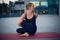 Beautiful young woman practices yoga asana Marichiasana 4 - sage pose outdoors against the background of a modern city