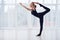 Beautiful young woman practices yoga asana Natarajasana - Lord Of The Dance pose at the yoga studio