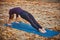 Beautiful young woman practices yoga asana Purvottanasana Upward Plank Pose on the wooden deck in the autumn park.