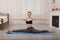 Beautiful young woman practicing yoga stretching on mat doing splits