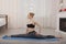 Beautiful young woman practicing yoga stretching on mat doing splits