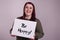 Beautiful young woman presenting a sign that says Be Happy painted on whiteboard