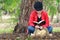 Beautiful young woman reading bible under big tree