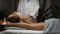 Beautiful young woman receiving legs and feet massage in spa salon, masseur doing professional massage