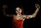 Beautiful young woman in red dress entangled in a rope cobweb on a black background