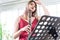 Beautiful young woman in a red dress playing the clarinet .,Classical musician oboe playing