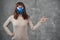 Beautiful young woman in respirator stand on grey background