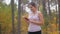 Beautiful young woman selecting music track on smartphone before jogging at forest