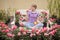 Beautiful young woman with short blond hair meditating roses in garden