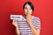 Beautiful young woman with short hair holding welcome paper covering mouth with hand, shocked and afraid for mistake