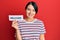 Beautiful young woman with short hair holding welcome paper looking positive and happy standing and smiling with a confident smile