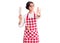 Beautiful young woman with short hair wearing professional baker apron holding knife with open hand doing stop sign with serious